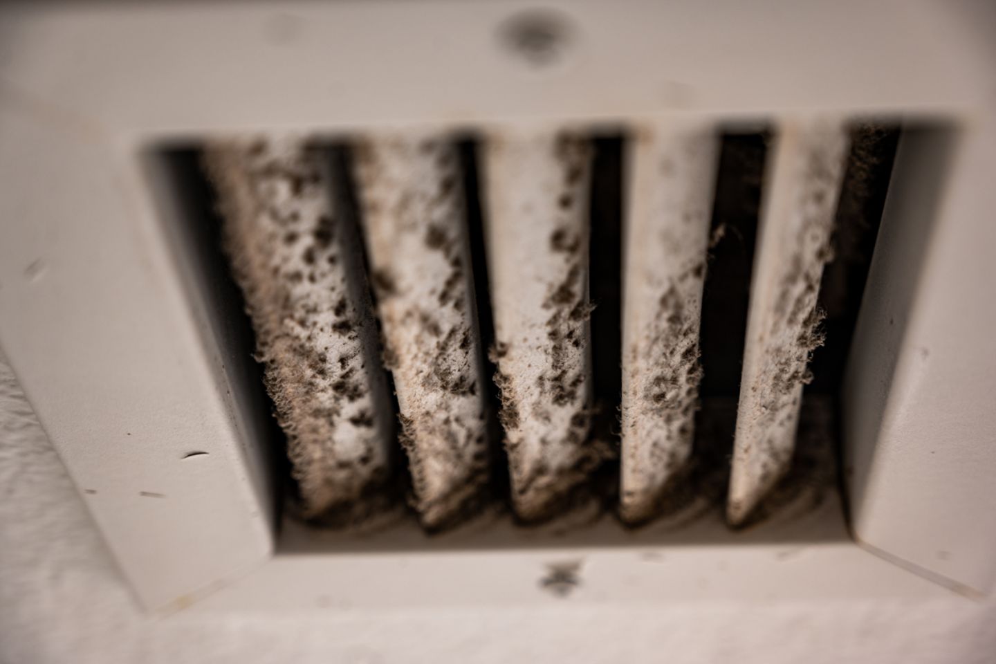A stained air vent on a white wall, illustrating the necessity for HVAC mold removal services in Rockford, IL.
